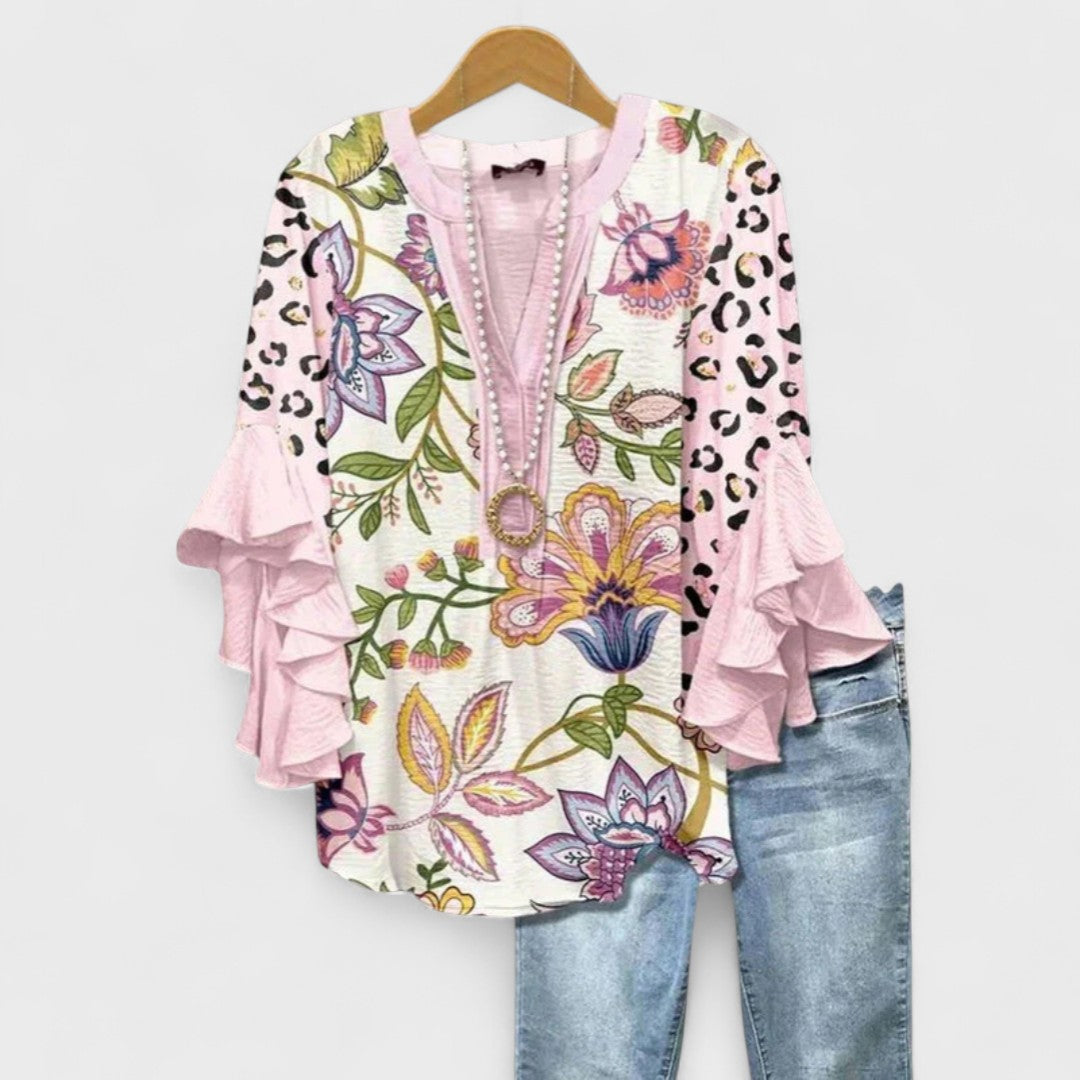 Essential women's spring top: a lightweight floral print blouse with a V-neck and ruffled sleeves.