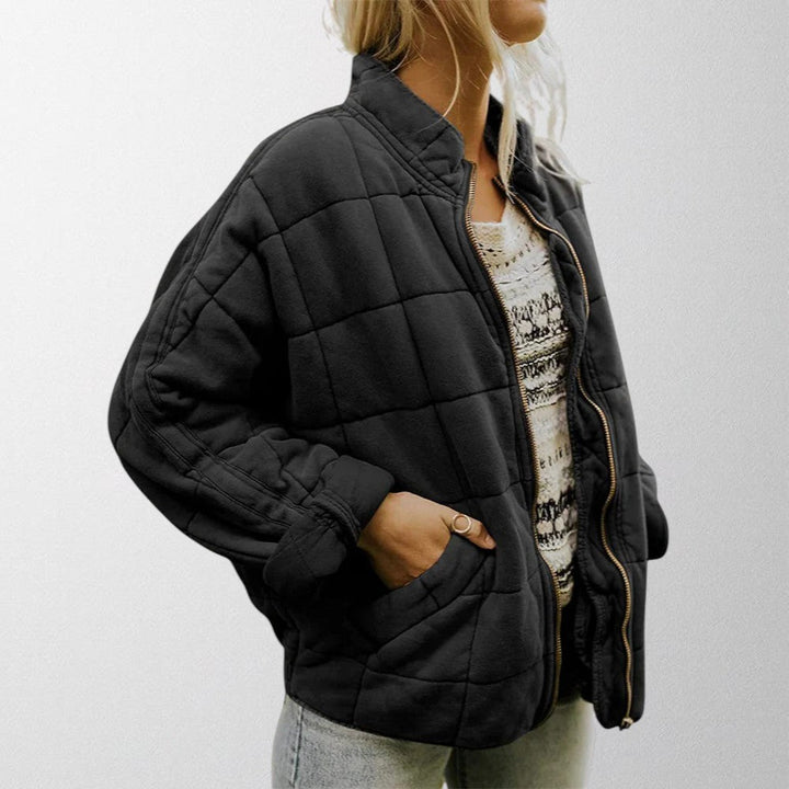 Full shot of a model wearing a women's lightweight quilted jacket, Zelda design.