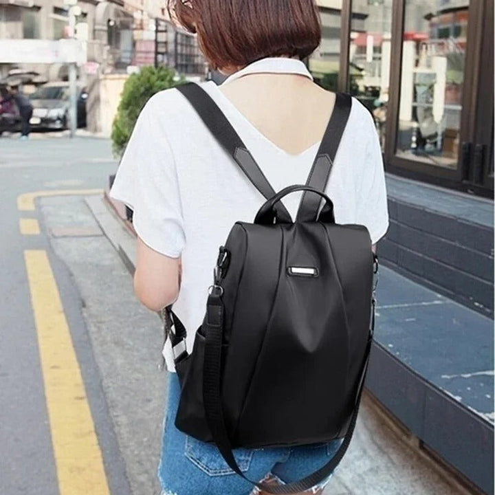 Versatile women's lightweight nylon backpack, designed for multi-way carry, perfect as a travel or shoulder bag.