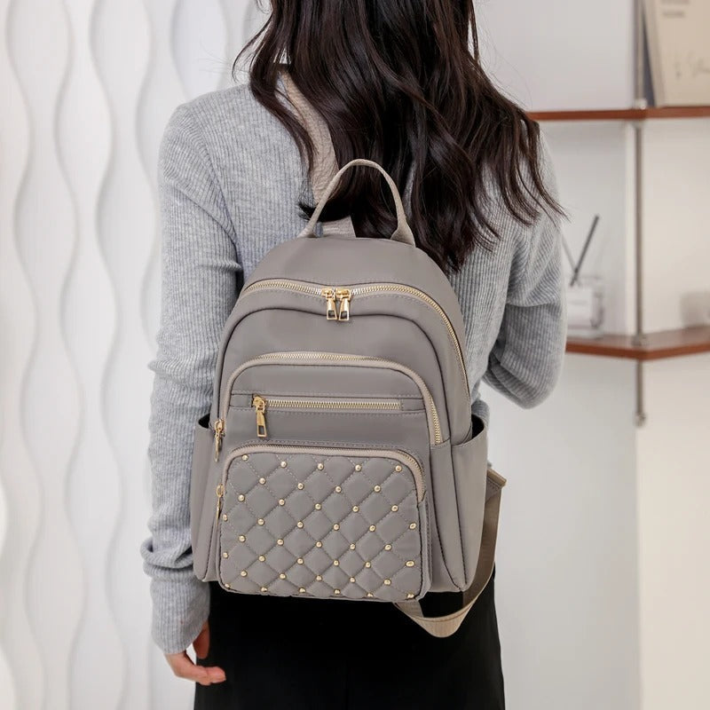 Water-resistant nylon women's backpack, lightweight and durable for travel, school, or daily outings.