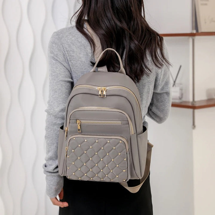 Water-resistant nylon women's backpack, lightweight and durable for travel, school, or daily outings.
