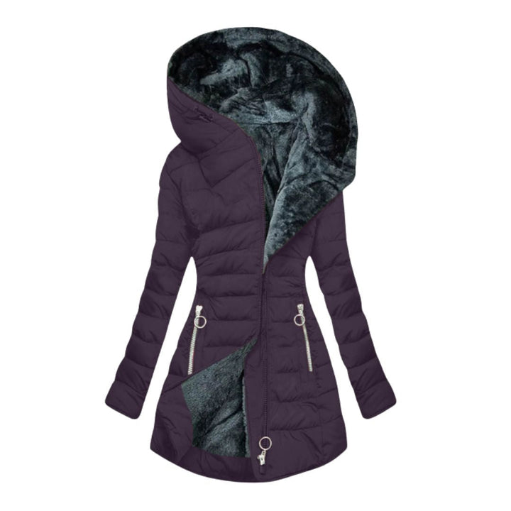 Full shot of a woman wearing a blue hooded waterproof winter coat outside in nature.