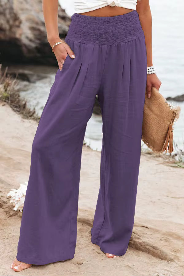 Stylish women's wide leg linen trousers with a flattering smocked waist, great for summer.