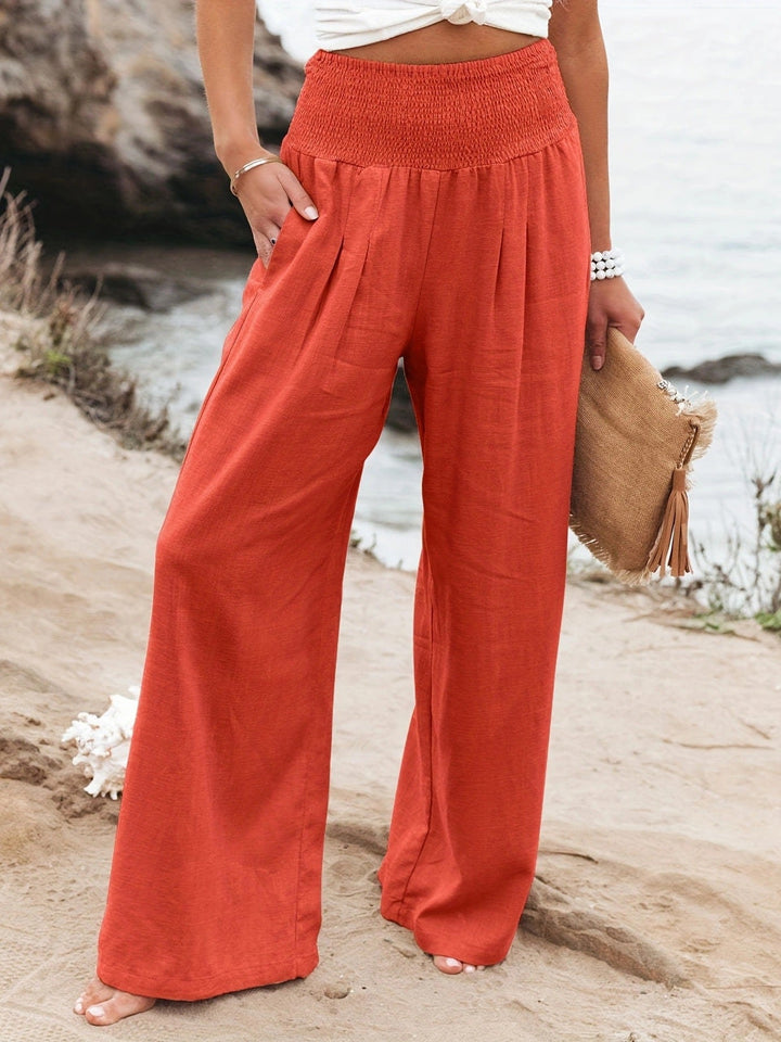 Product shot: Women's lightweight wide leg linen trousers on a hanger, ready for summer.