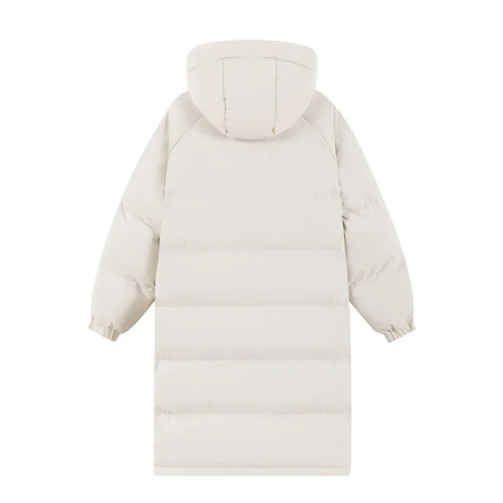 Stylish woman on a snowy mountain wearing a long blue puffer ski jacket, ideal for winter sports