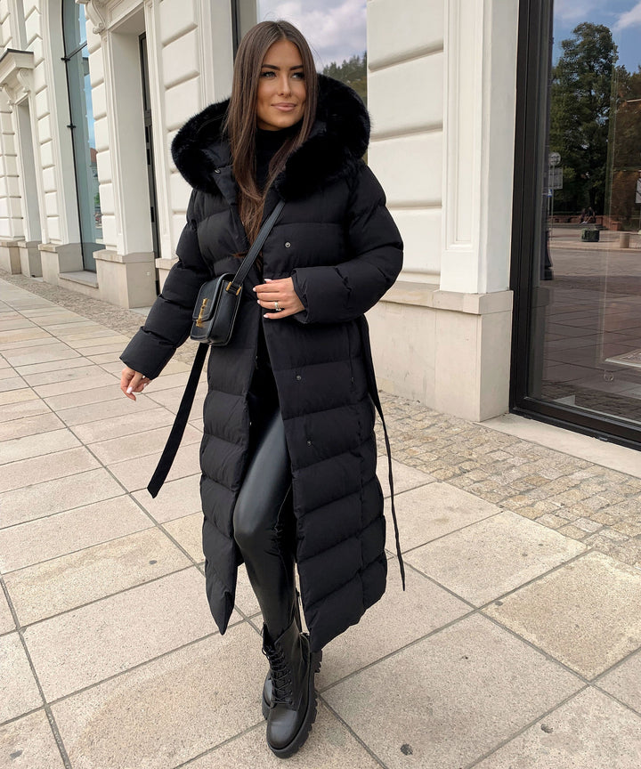 Women's long quilted winter parka with a cozy hood & stylish belt, perfect for cold weather.
