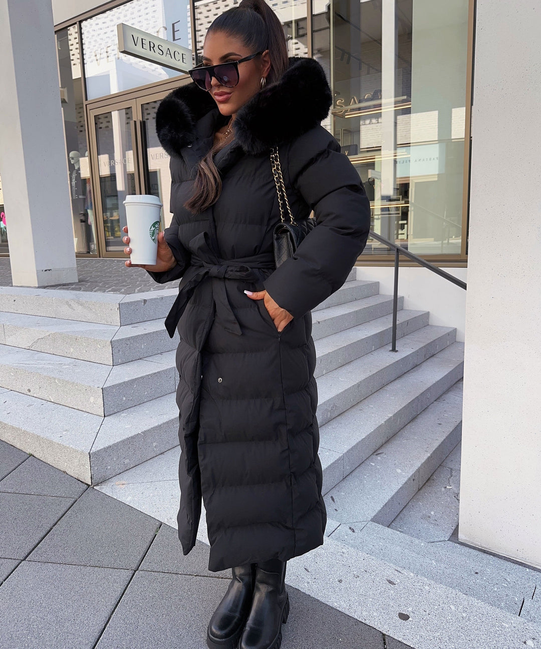 Detail of the adjustable belt on a women's long quilted parka, enhancing the waistline.