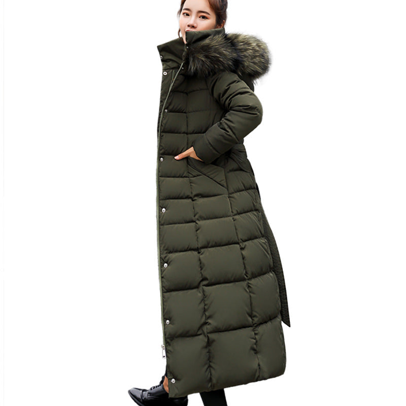 Model wearing a women's long quilted hooded winter coat, walking outdoors. Warm & fashionable.