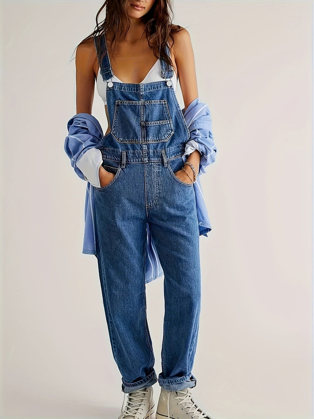 Woman wearing casual loose fit denim dungarees, a comfy everyday outfit with relaxed fit.