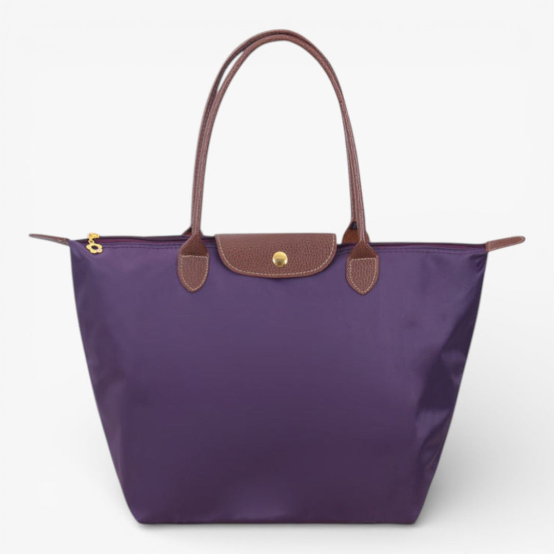 Woman modeling a stylish luxury shoulder handbag. Spacious & secure with zip, perfect for fashion.