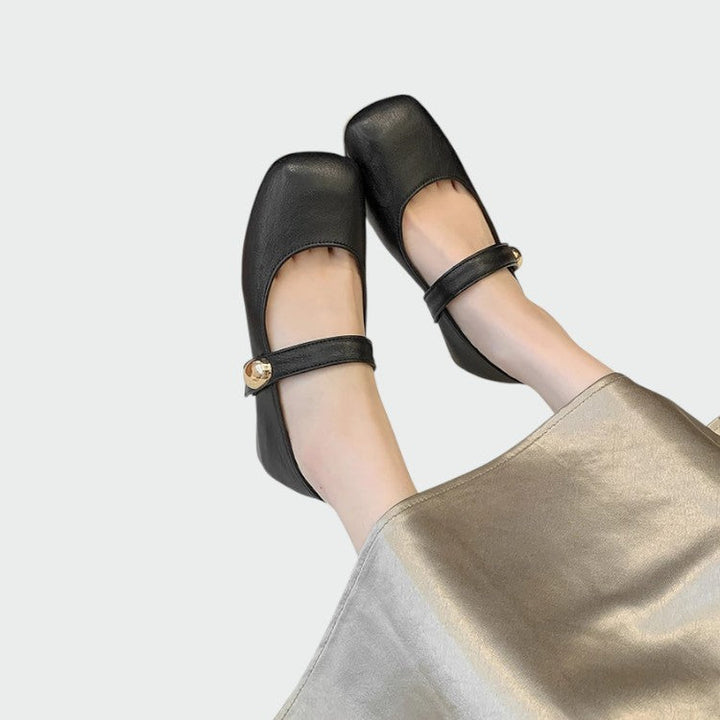 Minimalist women's black flats with classic Mary Jane buckle strap, perfect for sophisticated comfort.