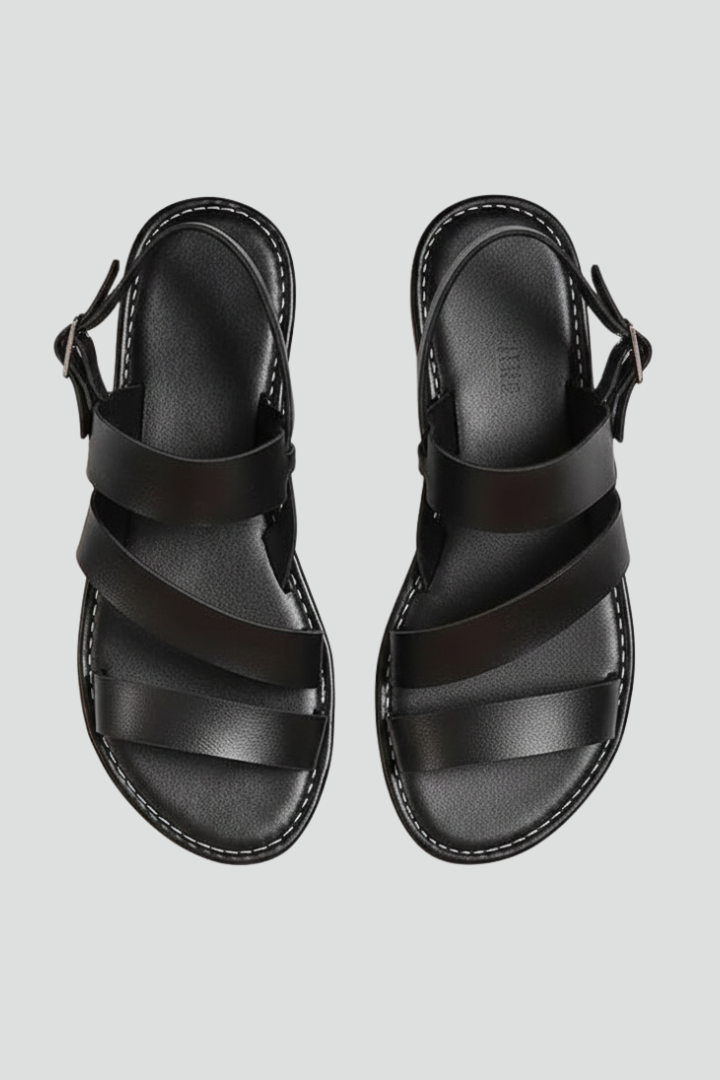 Women's modern black flat sandals with secure back strap, minimalist everyday design.