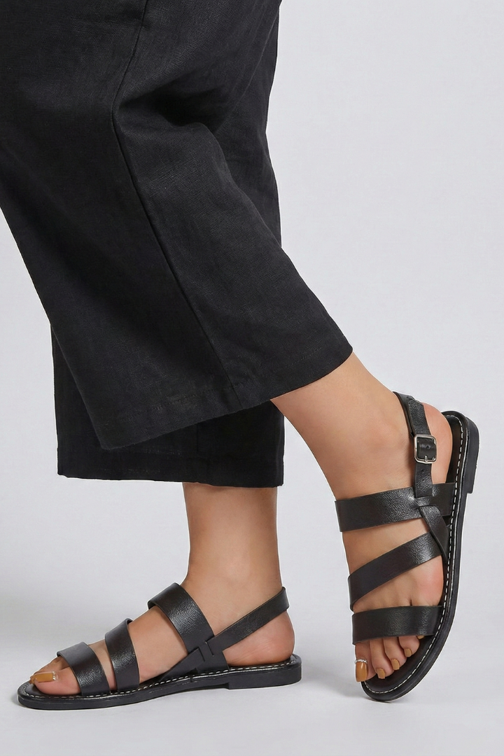 Pair of womens flat sandals, sleek white design with secure back strap, ideal for casual wear.