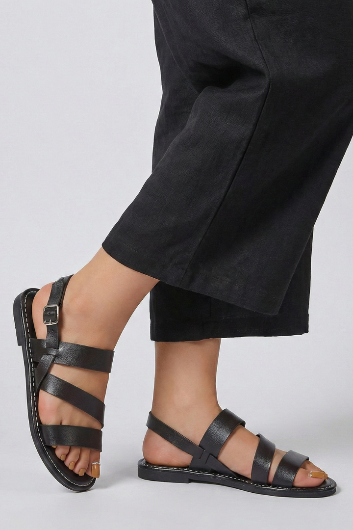 Close-up of the secure back strap on modern women's flat sandals, offering comfort.