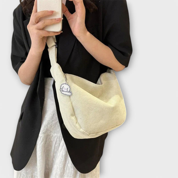 Close-up of a women's elegant curved shoulder bag, highlighting its sophisticated design