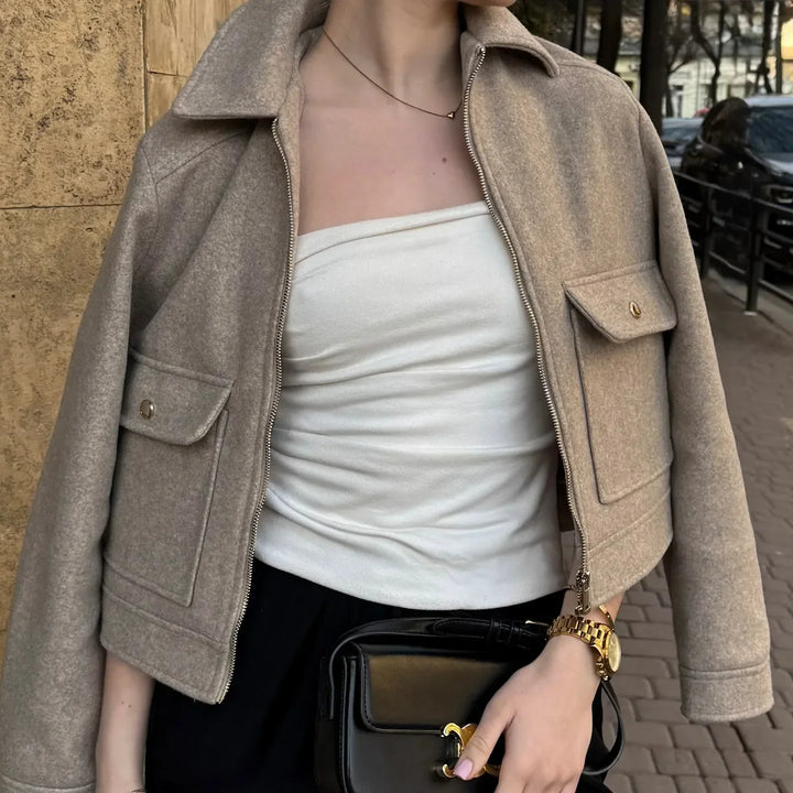 Close-up of women's black cropped utility jacket with silver zip-up closure, fashion outerwear, casual style