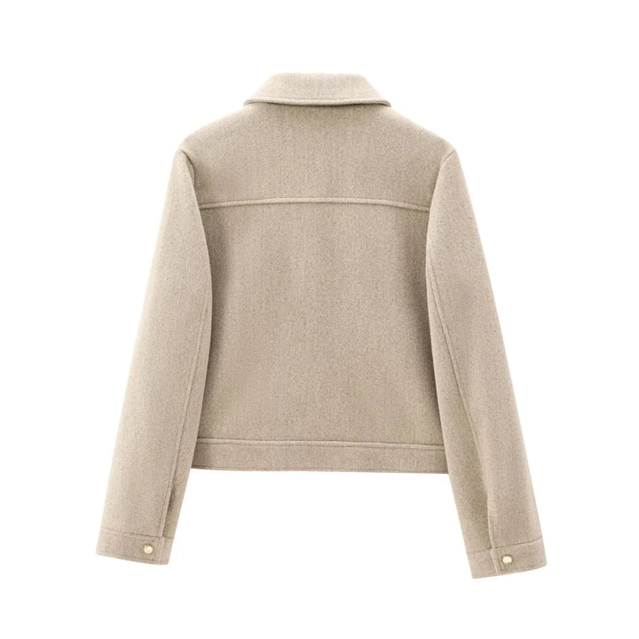 Front detail of a women's white cropped utility jacket, full zip-up, with visible pockets, fashionable outerwear