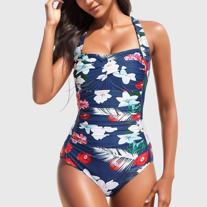 Close-up of women's one-piece swimsuit with detailed tropical floral print, summer beachwear.