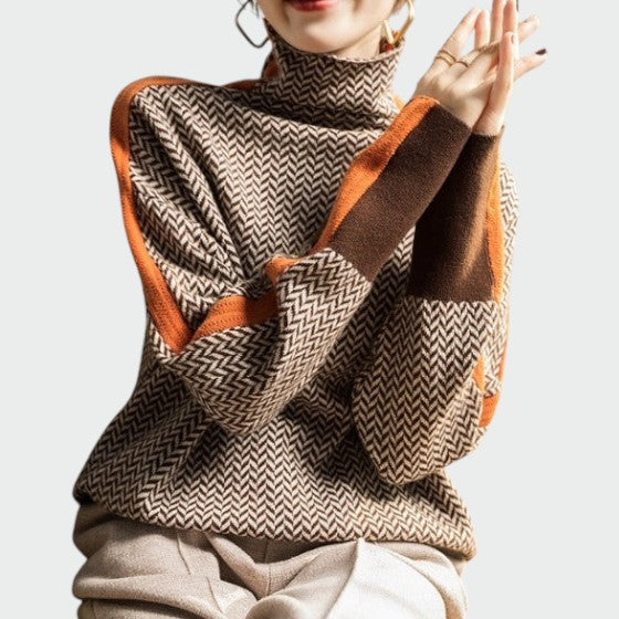 Close-up of a women's striped herringbone turtleneck sweater in orange and green, elegant fall fashion.