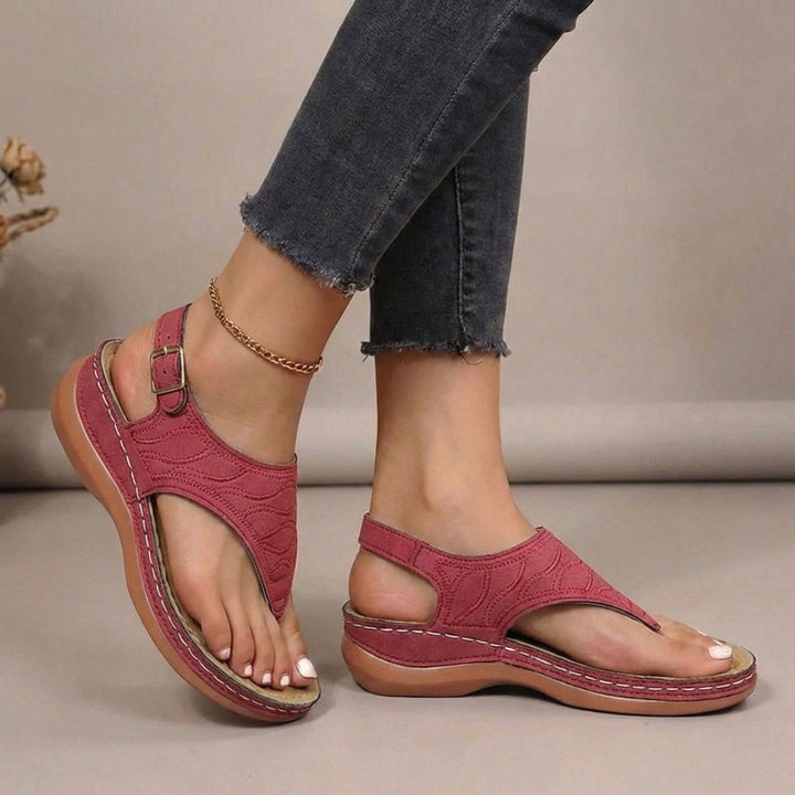 Stylish women's flat thong sandals featuring orthopaedic arch support and adjustable straps for summer.