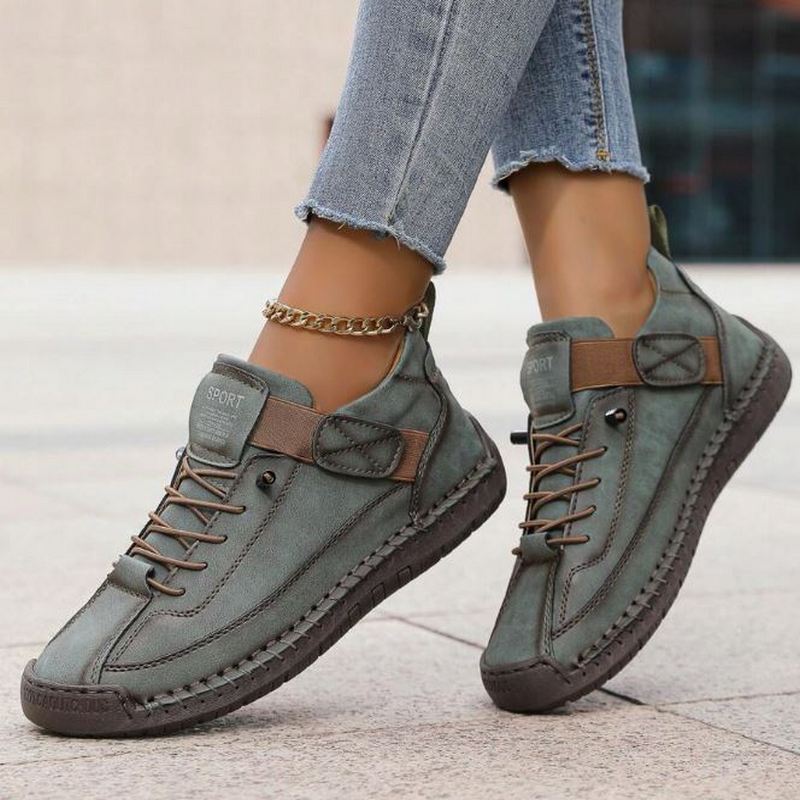 Female hand holding a Women's Orthopedic Sneaker, highlighting its lightweight design
