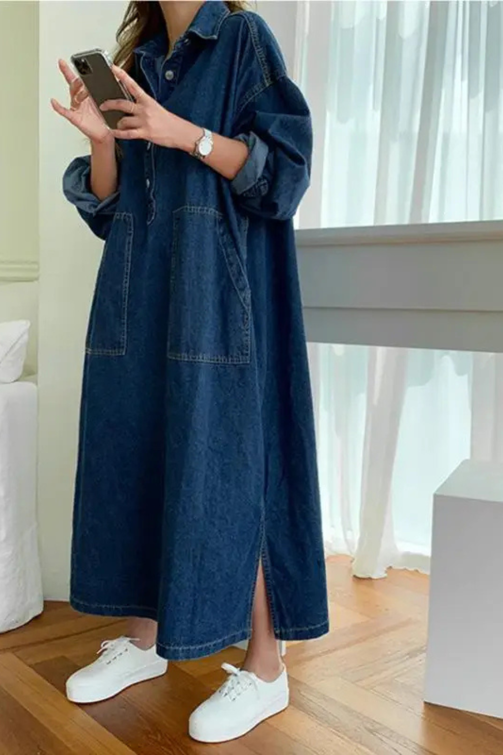 Relaxed fit women's long sleeve denim maxi dress. Oversized, collared, and features practical pockets for casual style.