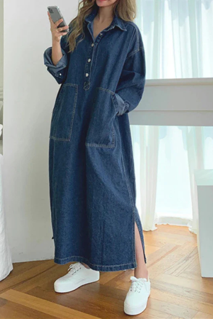 Chic women's blue denim maxi dress with an oversized fit, collared neckline, long sleeves, and practical side pockets.