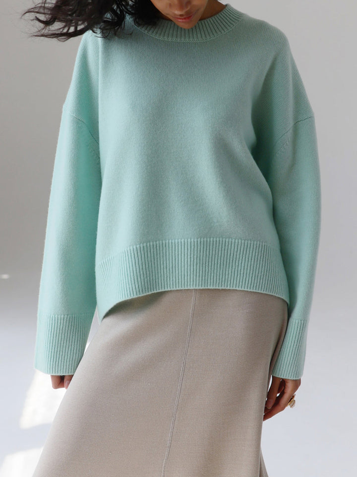 Horizontal view of a women's oversized knit sweater, showcasing knit pattern