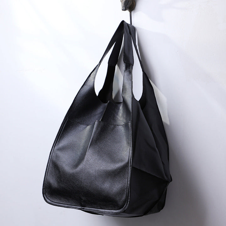 Detail of metal buckle and stitching on flap closure of women's vintage leather shoulder bag