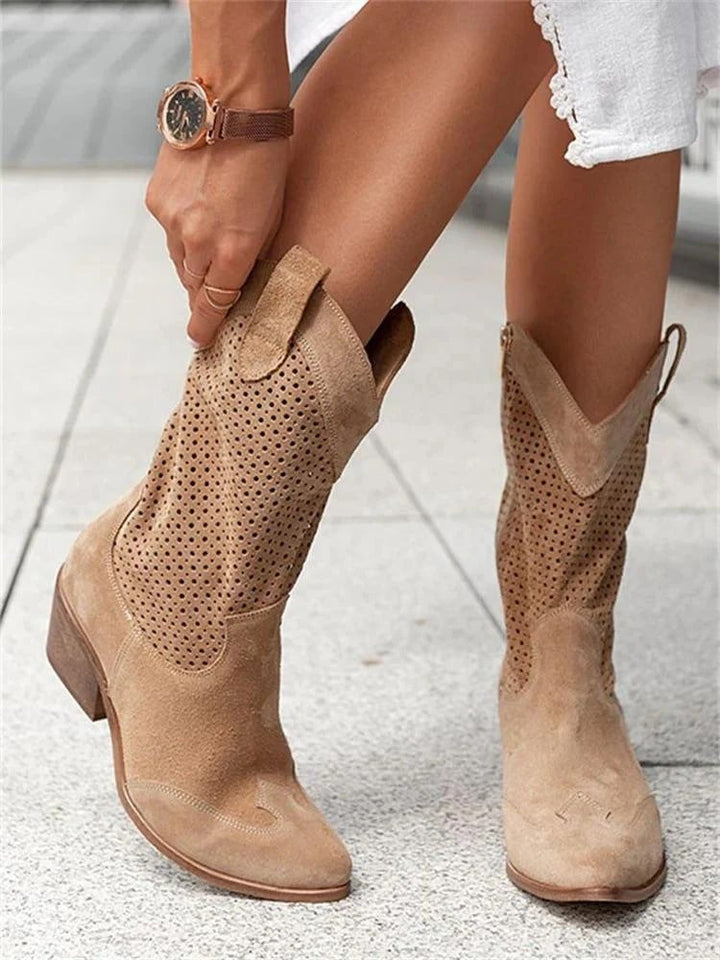 Detailed perforated women's western ankle boots. Cowboy aesthetic with block heel, pointed toe, & easy pull-on fit.