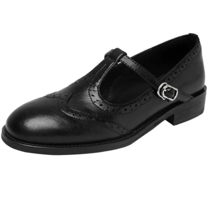 Detailed view of women's black polished T-strap Mary Janes, classic brogue style comfortable flats