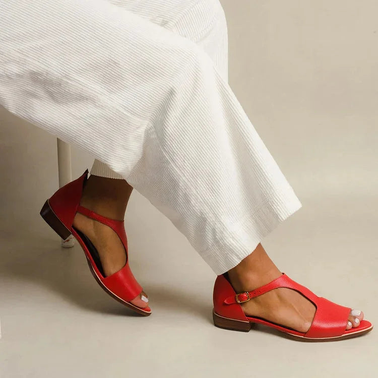 Women's red T-strap flat sandals with open toe and buckle design, ideal for summer casual wear.