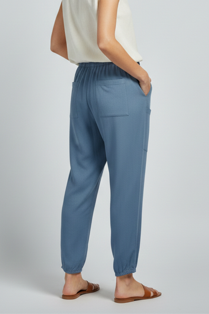 Front view of women's relaxed fit straight leg trousers with elastic drawstring waist and button hem.