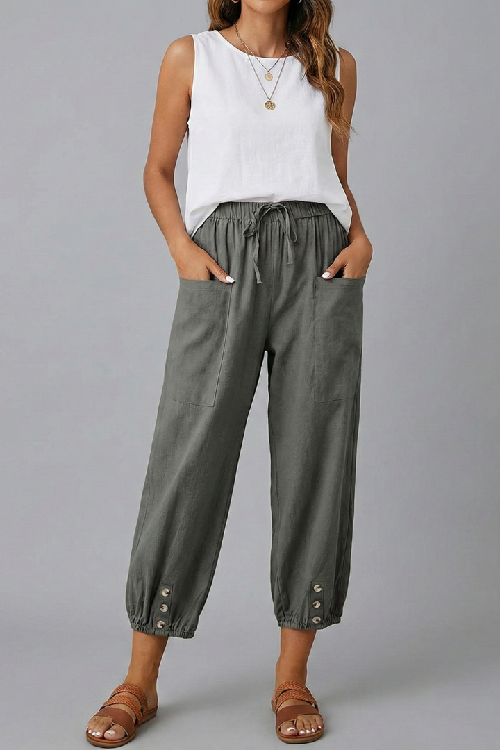 Close-up of the drawstring waist and button hem on women's versatile summer trousers.