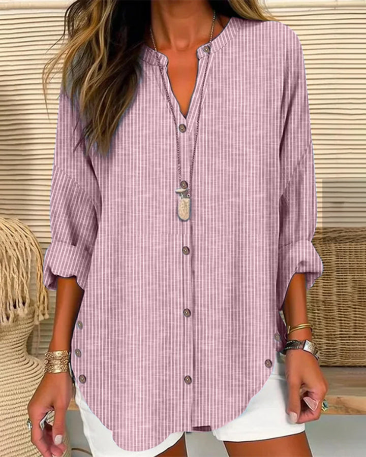 Close-up of a striped button-down blouse for women, showcasing the fabric and button details.