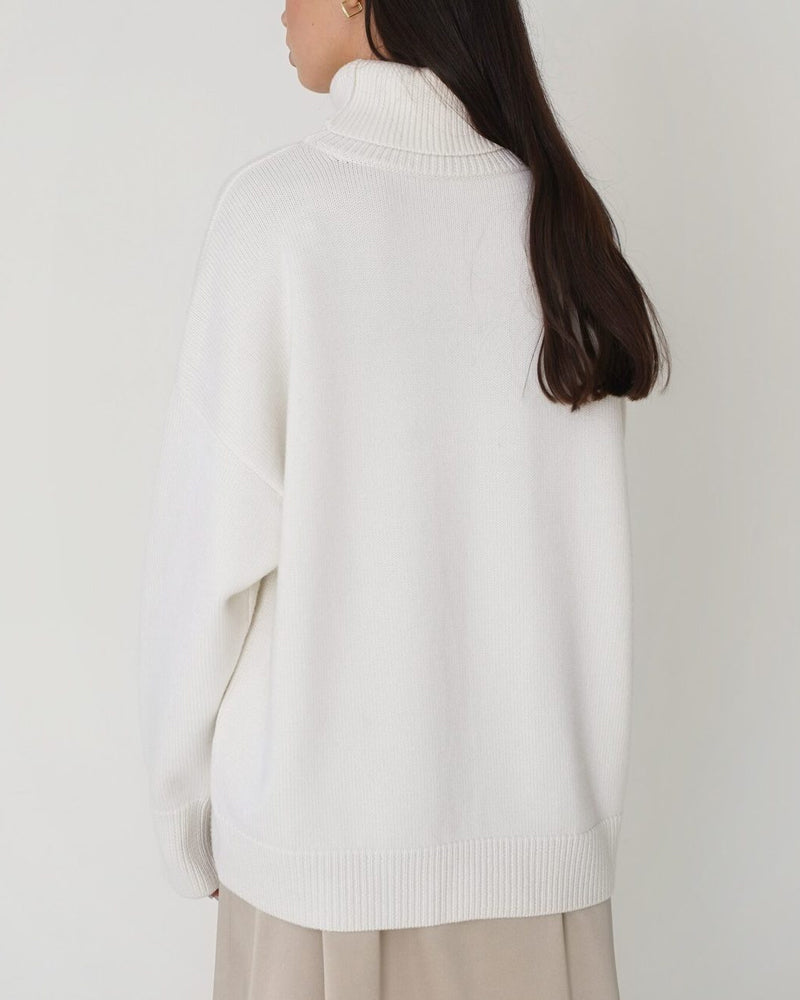 Close-up of a women's solid color relaxed turtleneck sweater with long sleeves, spring fashion