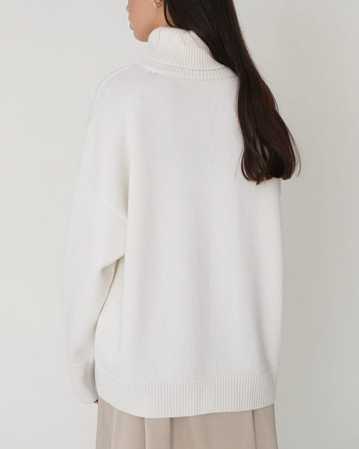 Close-up of a women's solid color relaxed turtleneck sweater with long sleeves, spring fashion