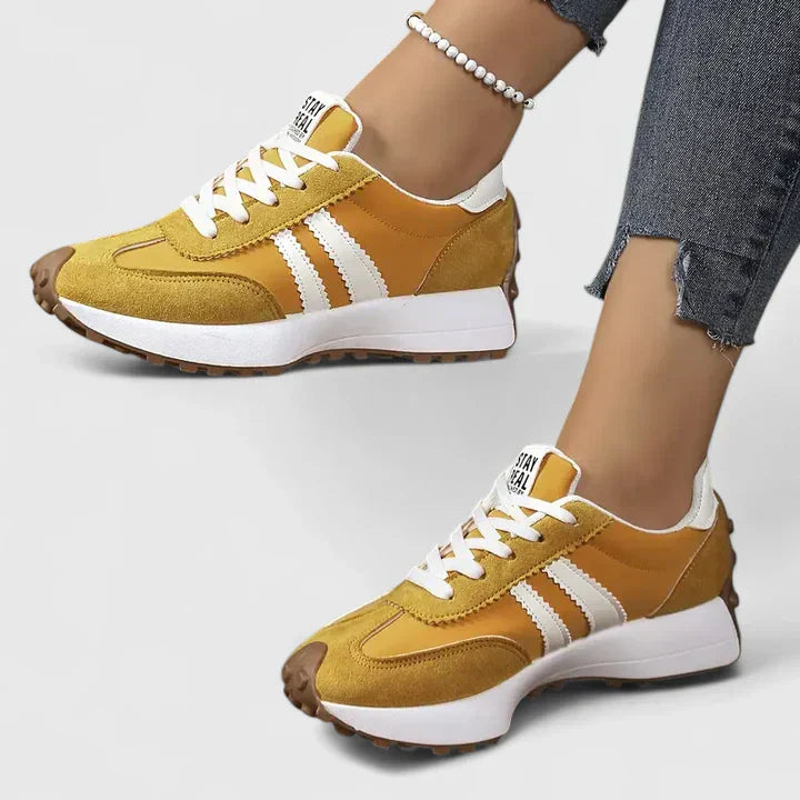 Close-up of women's vintage-style white lace-up sneakers, highlighting comfortable design and casual fashion.