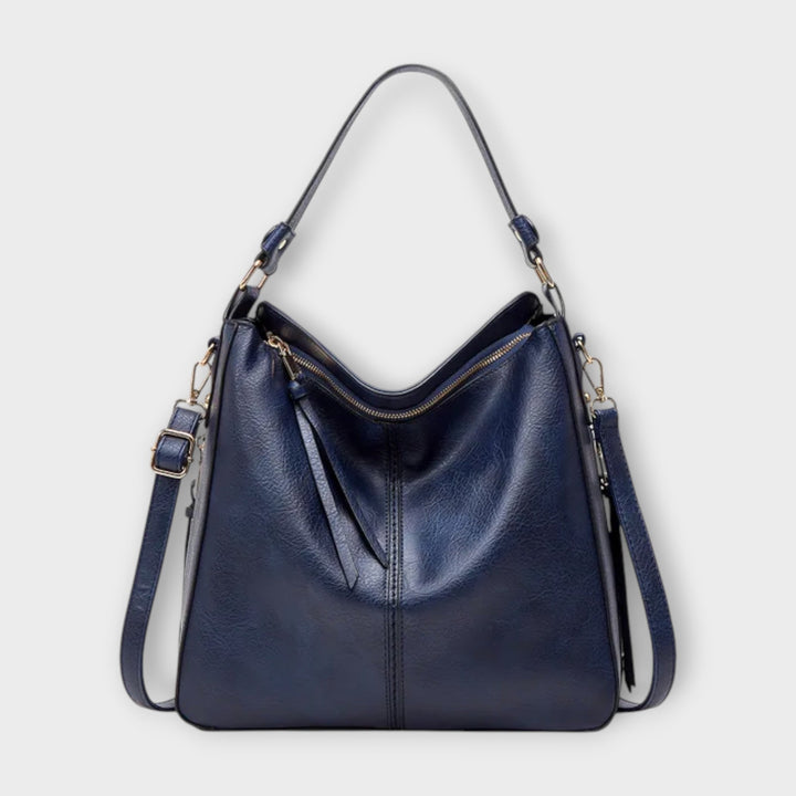 Close-up of a slouchy hobo bag, showing textured faux leather and adjustable crossbody strap