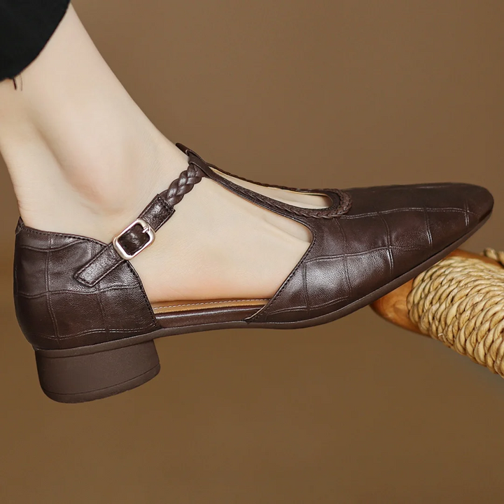 Close-up of a women's soft leather T-strap Mary Jane shoe, showcasing the strap and buckle detail