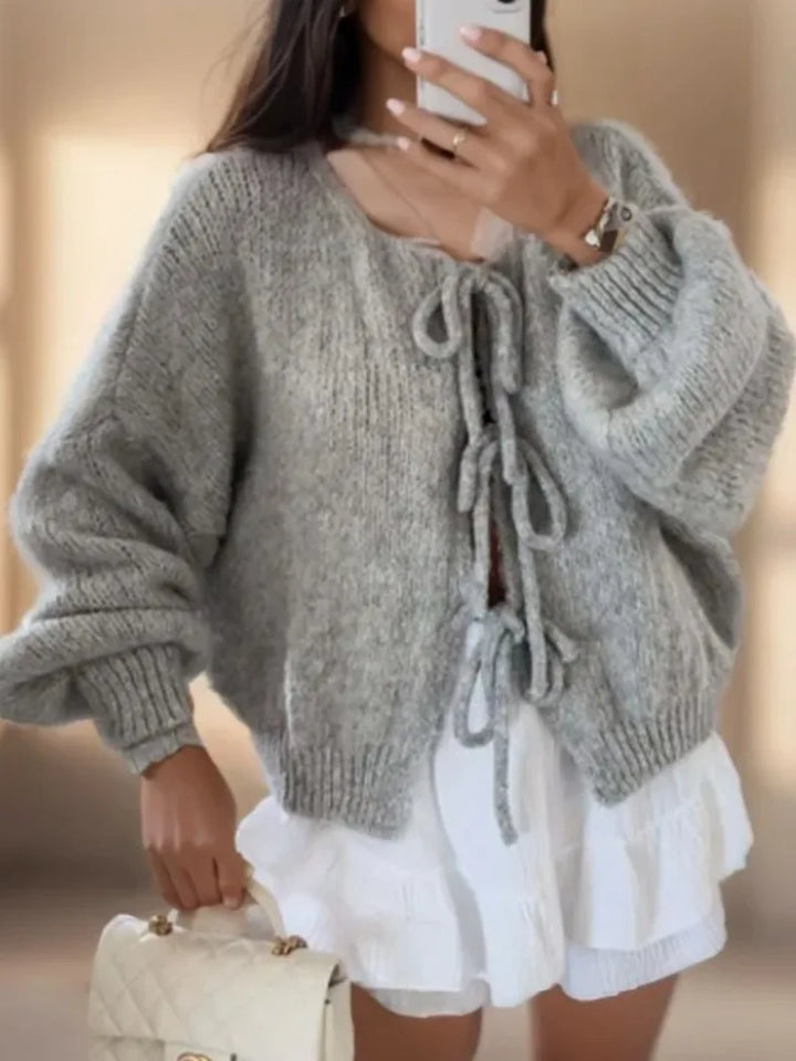 Women's soft knit cardigan with elegant bow ties, showcasing stylish layering for feminine fashion.