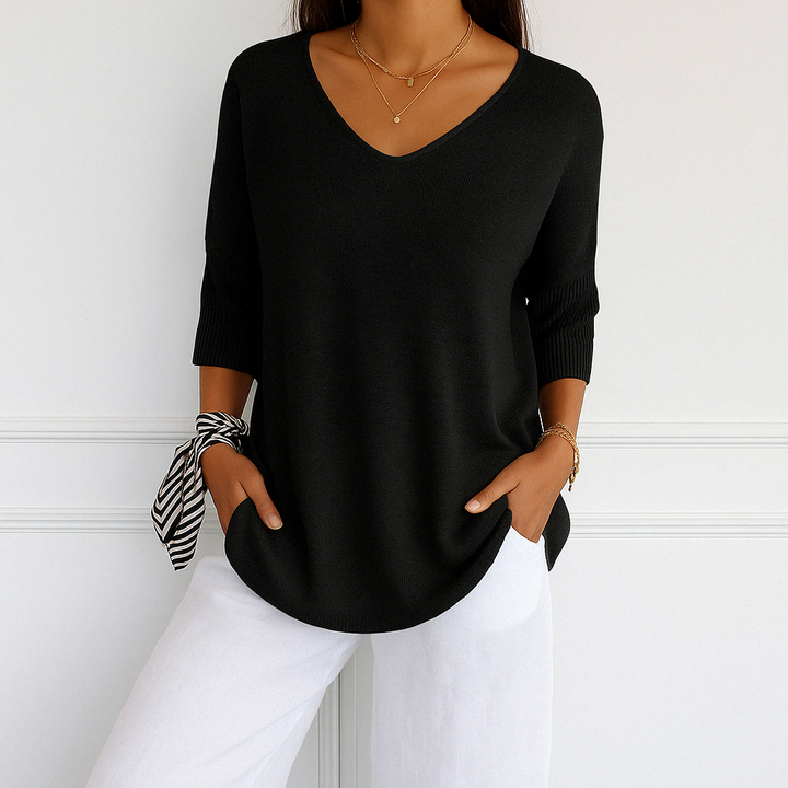 Model posing in a relaxed fit women's v-neck short sleeve lightweight sweater