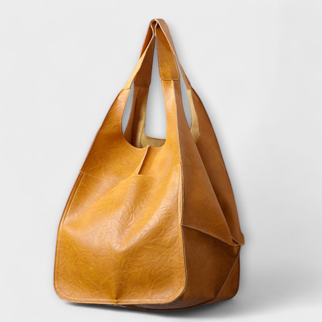Everyday women's bag from a side angle, highlighting its classic silhouette and generous depth.