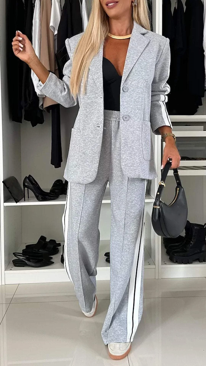Women's sporty chic two-piece suit with oversized blazer & striped trousers, perfect for casual elegance.