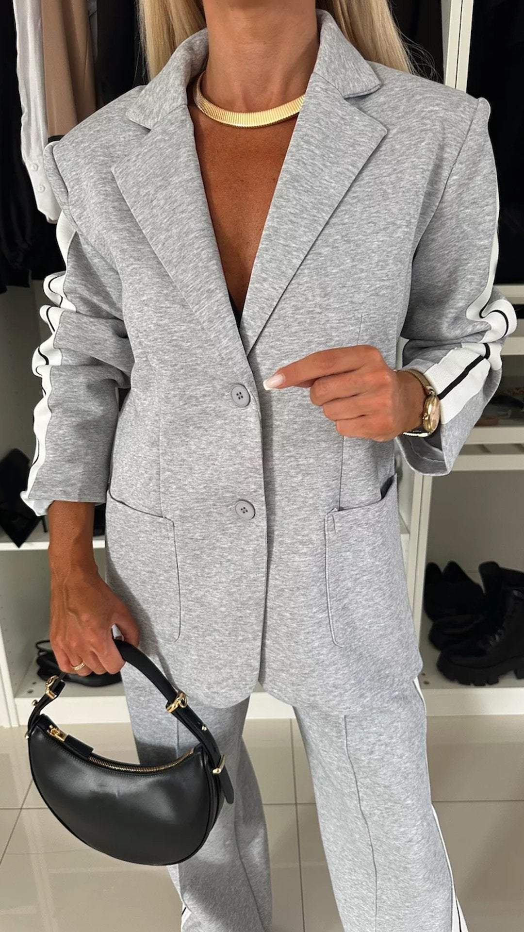 Women's two-piece suit: sporty blazer & striped pants, perfect for a chic modern look at any casual event.