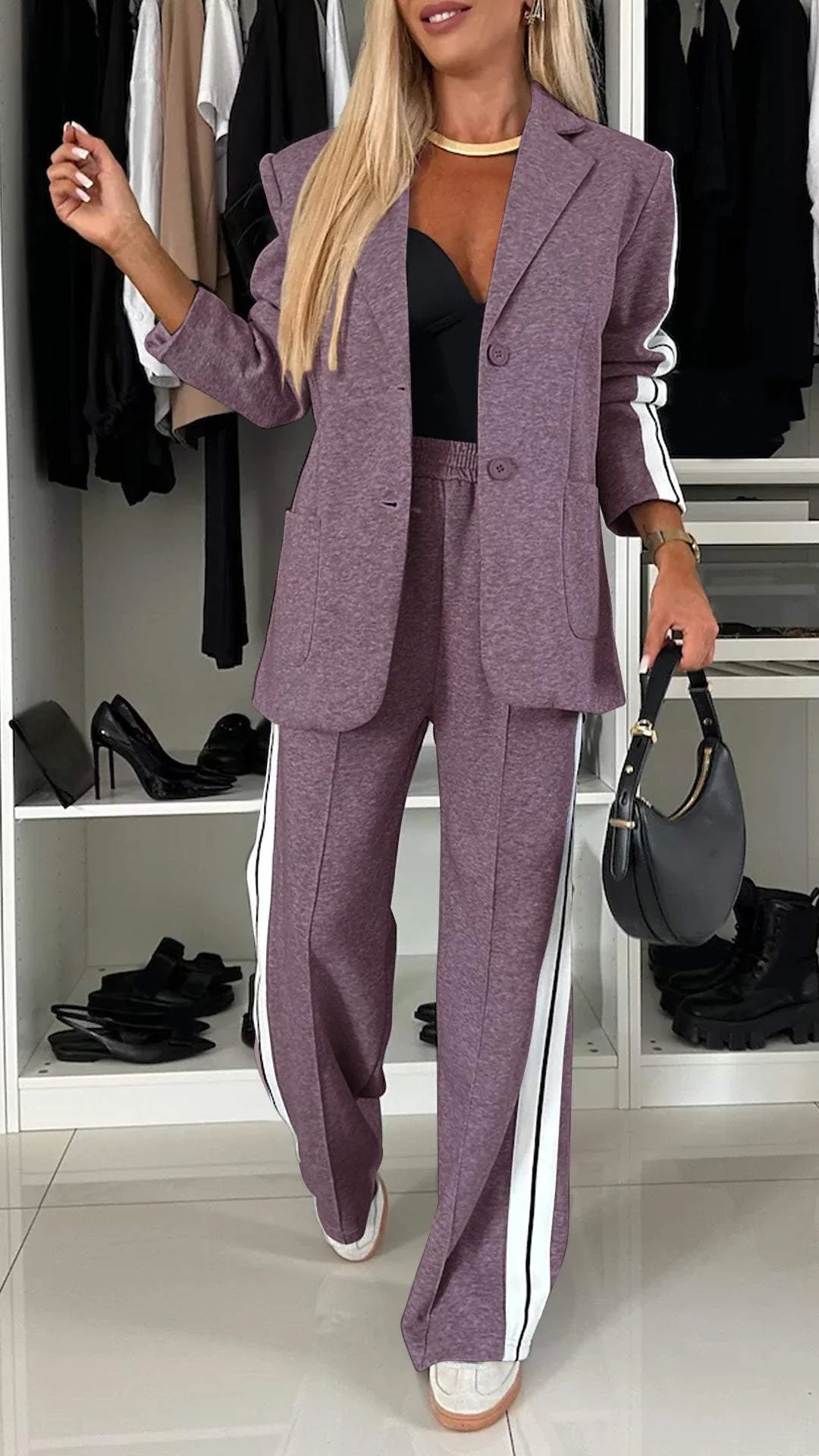 Elegant women's two-piece suit featuring a sporty blazer & fashionable striped trousers for a modern look.