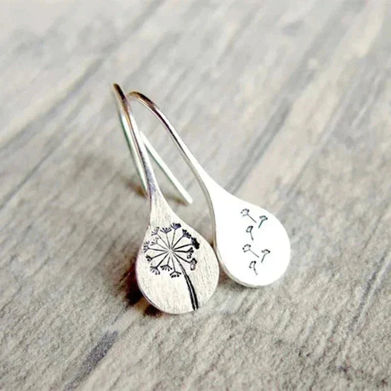 Elegant women's sterling silver dangle earrings featuring delicate dandelion within teardrop design. Nature jewelry.