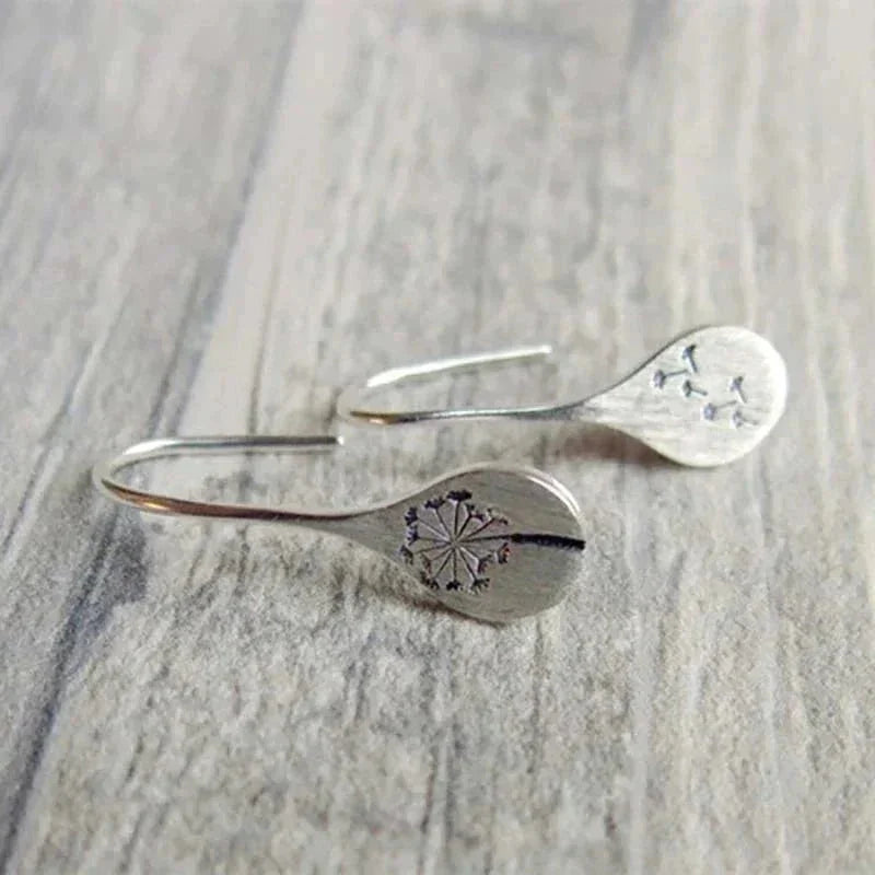 Women's elegant sterling silver teardrop dangle earrings with unique dandelion motif. Nature-inspired silver jewelry.