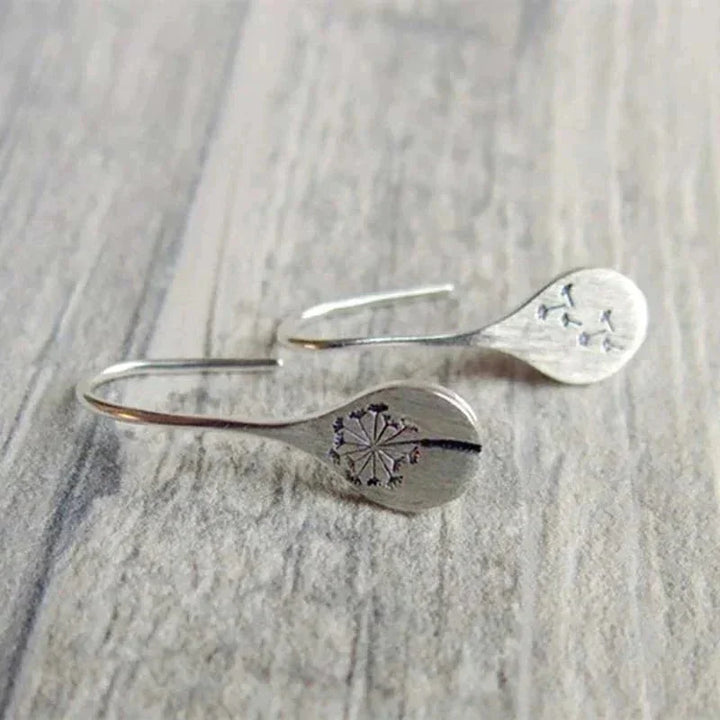 Women's elegant sterling silver teardrop dangle earrings with unique dandelion motif. Nature-inspired silver jewelry.