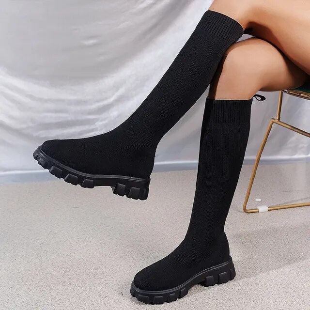 Close-up of women's fashion knit boots with a chunky sole, offering a stylish and stretchy fit.